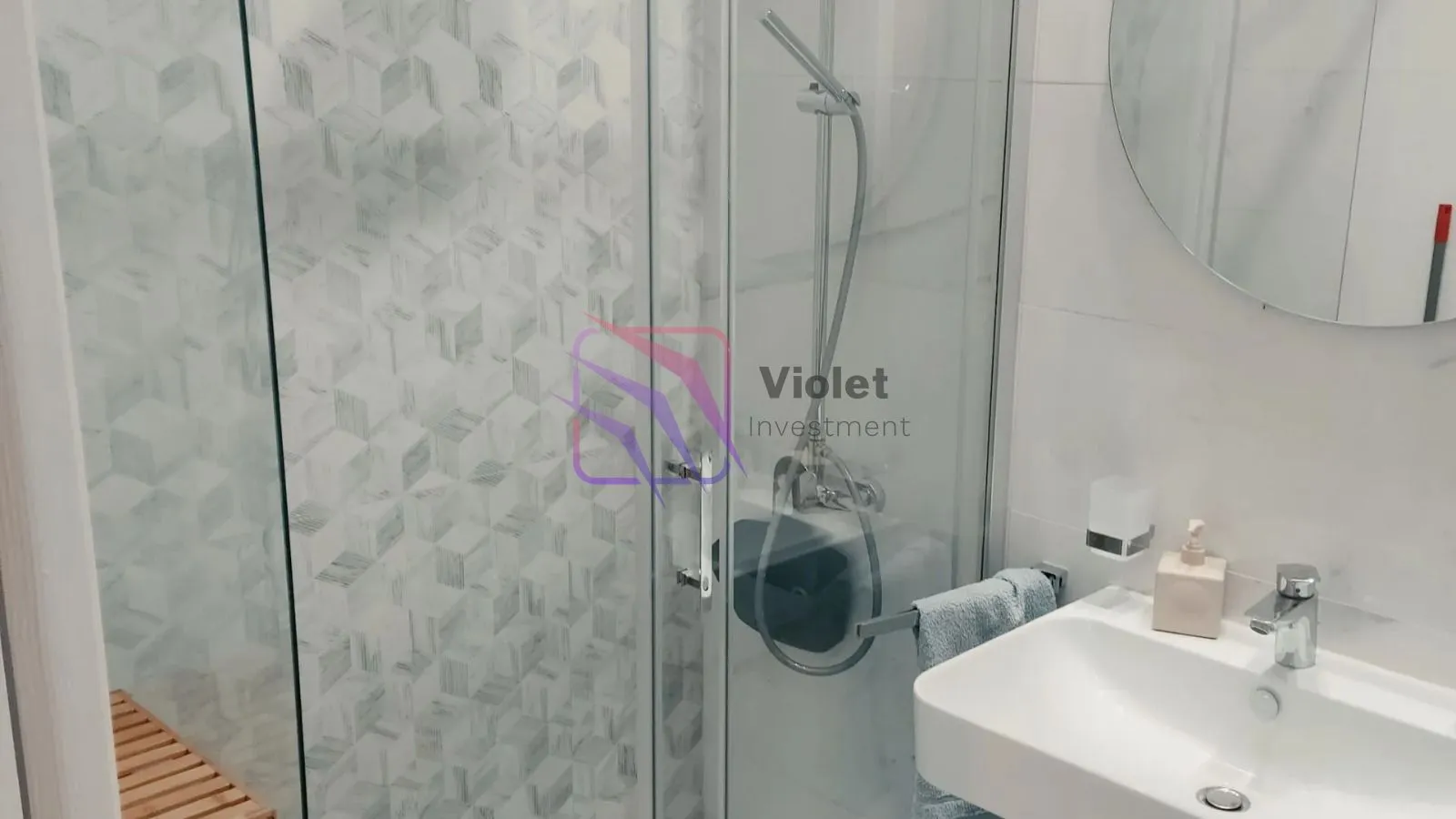 Moderne kupatilo sa tuš kabinom i umivaonikom.