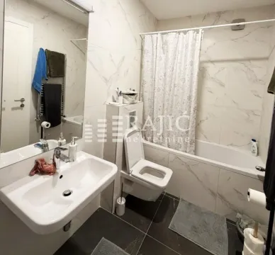 Modern bathroom with a sink, toilet, and bathtub. - image 10