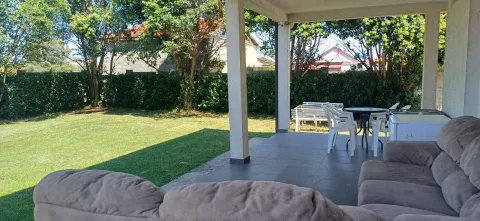 Covered terrace with seating furniture and a view of the yard. - image 3