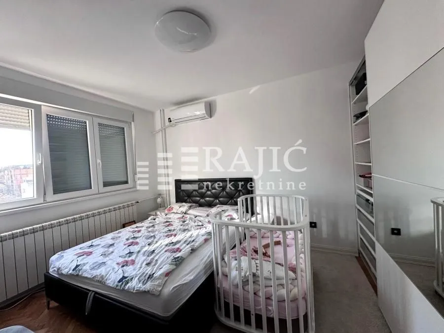 Furnished bedroom with a double bed and a baby crib.