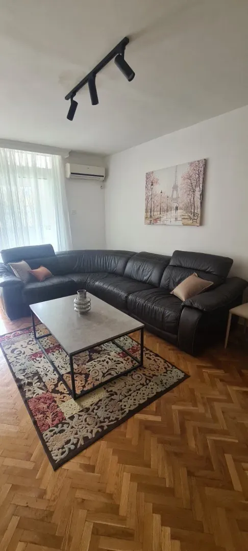 Svijetla dnevna soba sa kožnom ugaonom garniturom i klub stolom.