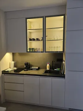 Modern kitchen with grey cabinets and illuminated glass display cases. - image 2