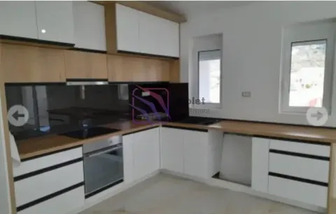 Moderna kuhinja sa bijelim elementima i drvenim radnim površinama. - image 15