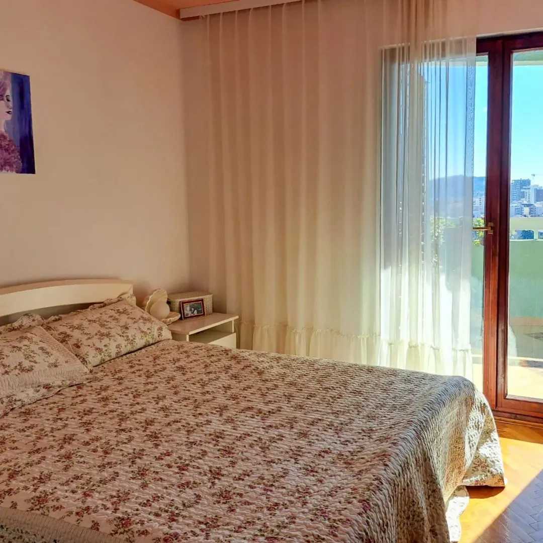 Spavaća soba sa bračnim krevetom i izlazom na terasu.