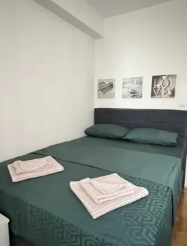 Bedroom with a double bed and decorative pictures on the wall. - image 4