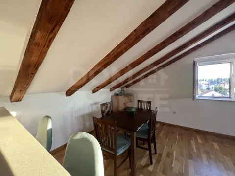 Attic space with wooden beams and a dining table. - image 4