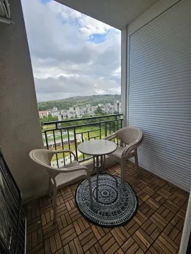 Furnished balcony with seating set and city view. - image 8