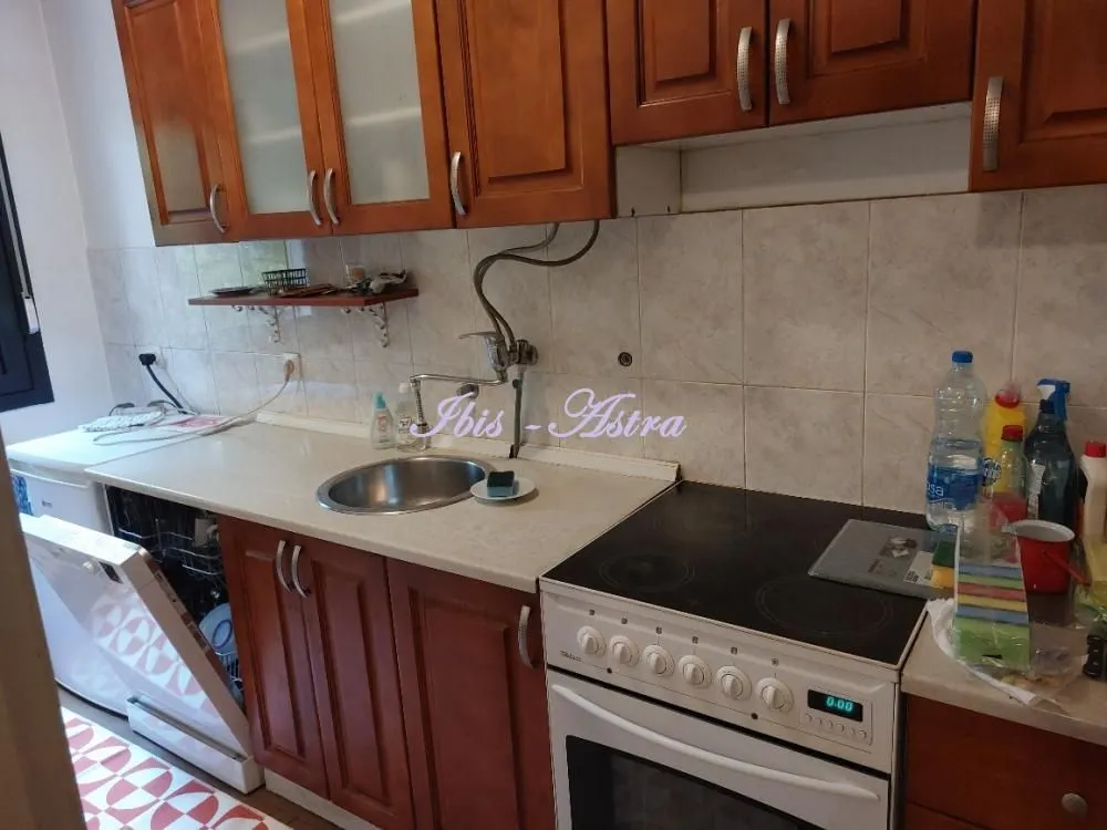 Kitchen with wooden cabinets, sink and stove.