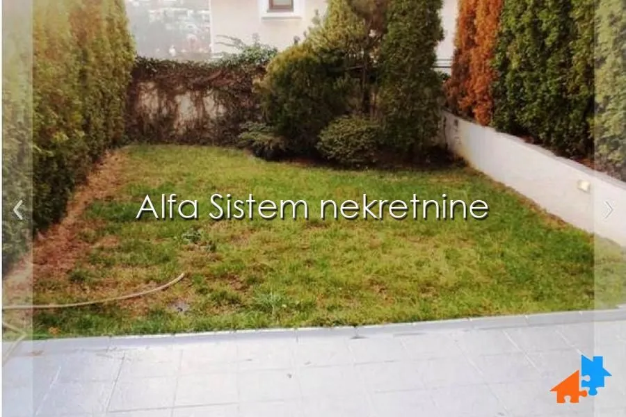 Small grassy yard with fence and vegetation.