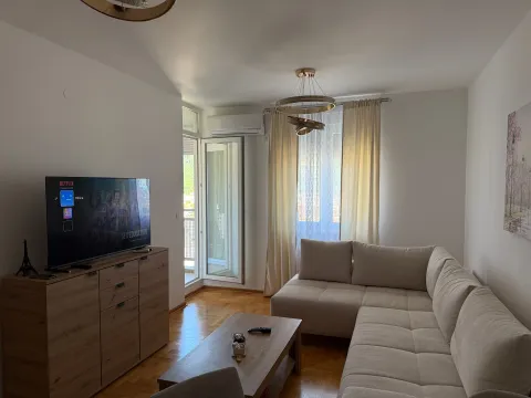 Bright living room with a sectional sofa, television, and access to the terrace. - image 4