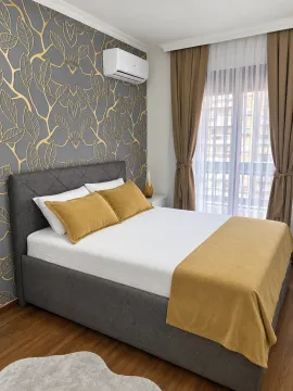 Furnished bedroom with a double bed, patterned wallpaper, and an air conditioner. - image 4
