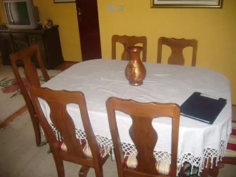 Trpezarijski sto sa drvenim stolicama u dnevnoj sobi sa žutim zidovima. - image 8