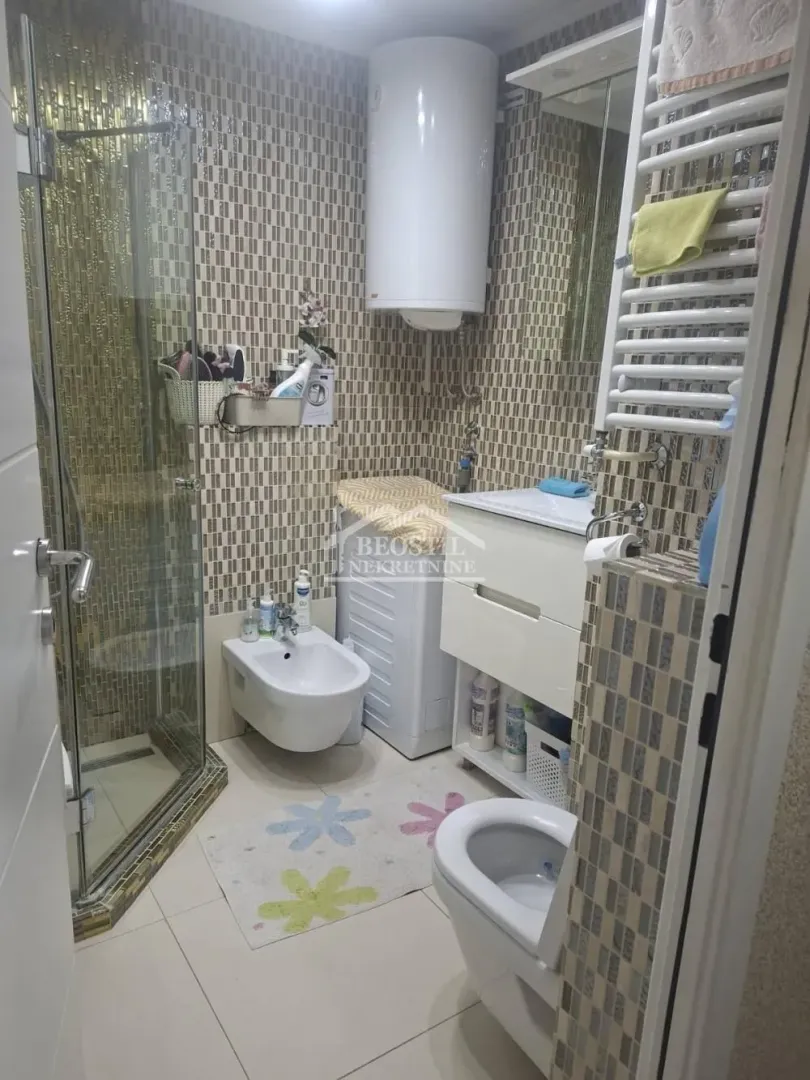 Compactly equipped bathroom with a shower cabin, washbasin, and toilet.