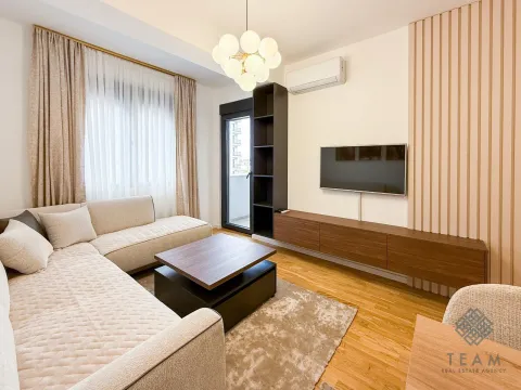Modern living room with a sectional sofa, TV, and balcony access. - image 4