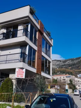 Pogled na spoljašnjost zgrade sa terasama i okolnim pejzažem. - image 7