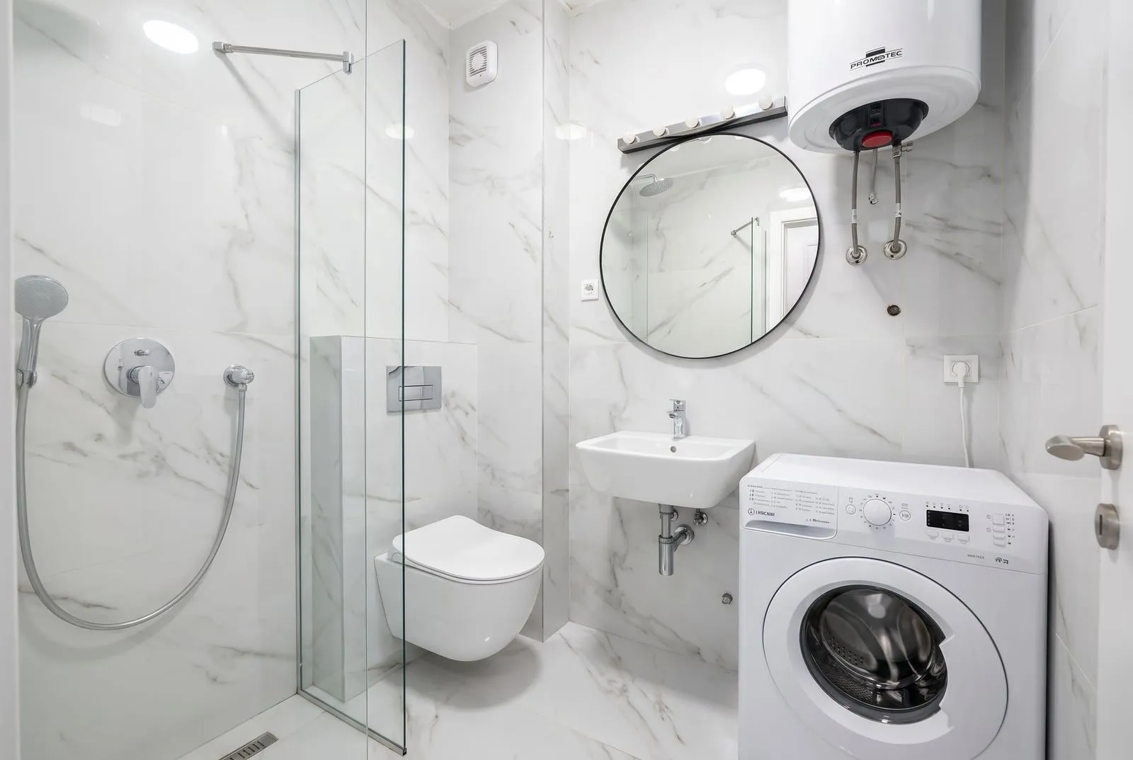 Moderne kupatilo sa tuš-kabinom, sanitarijama i veš mašinom.