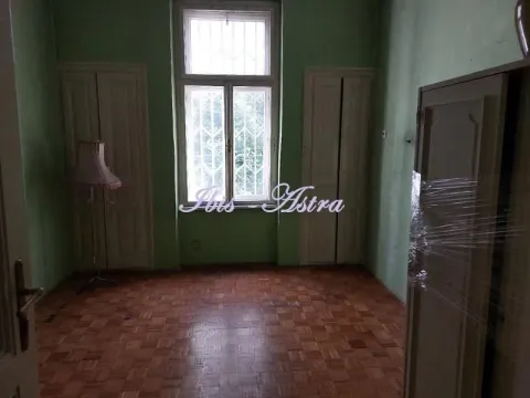 Empty room with parquet flooring, green walls, and a window with security bars. - image 9
