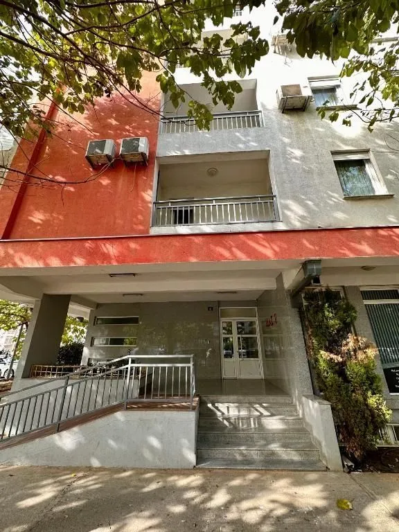 Ulaz u stambenu zgradu sa prilaznom rampom i stepenicama.