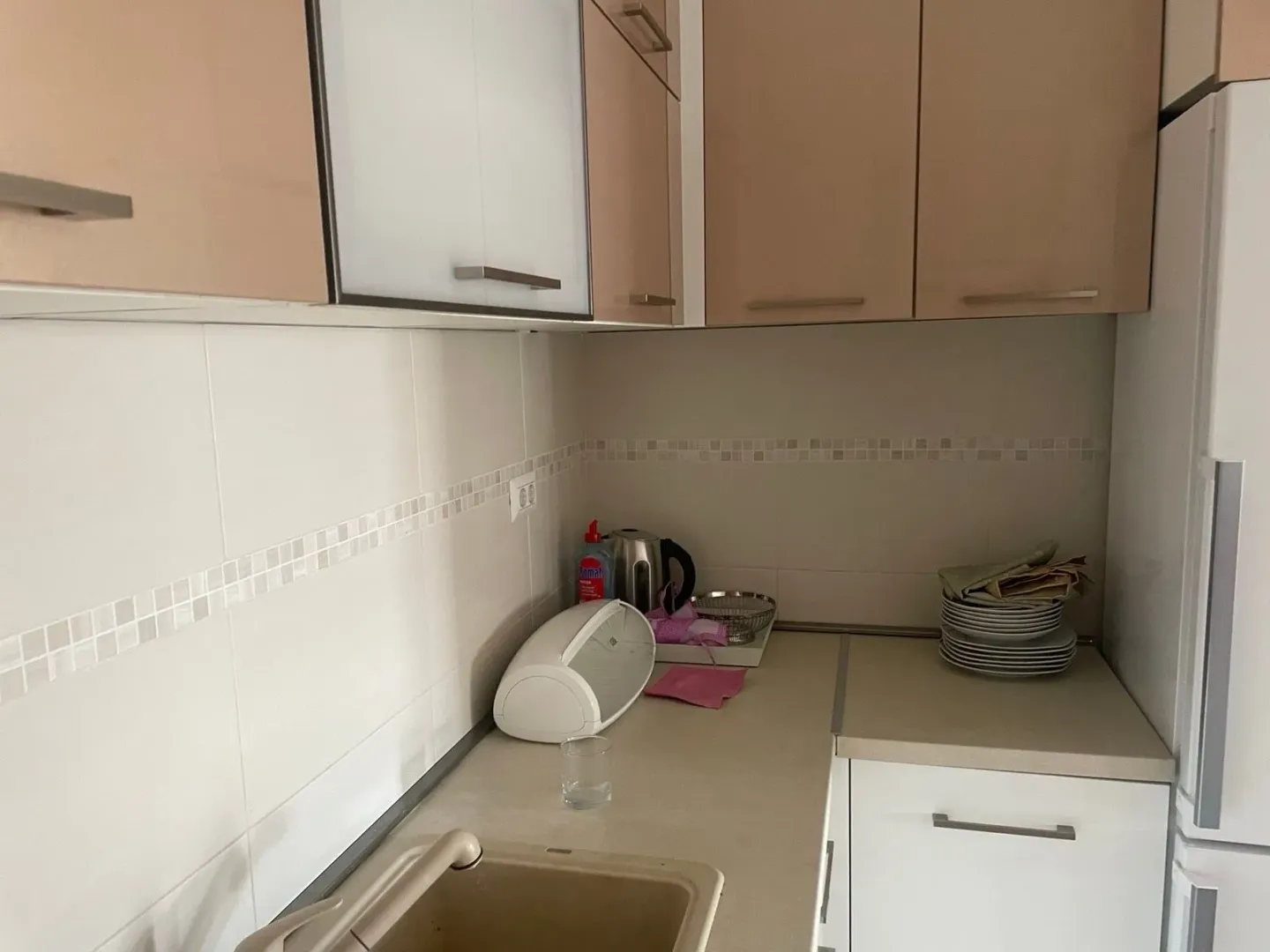 Small kitchen with light-colored cabinets and a sink.