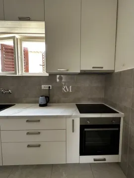 Modern kitchen with white cabinets and a built-in oven. - image 12