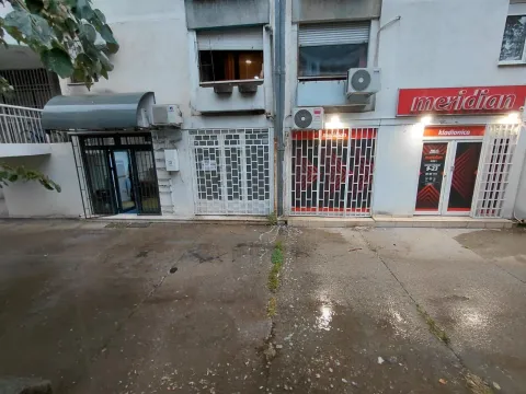 Exterior view of the ground floor of a building with commercial spaces and entrances. - image 8