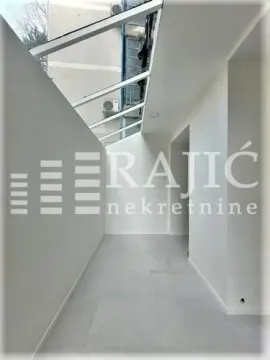 Enclosed space with a glass roof and white walls. - image 16