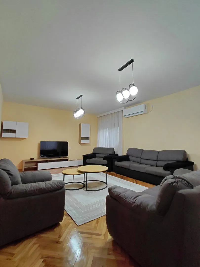 Spacious living room with seating set and TV unit.