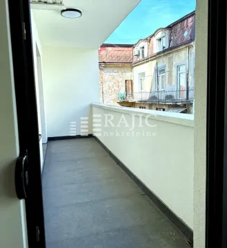 Dugačka terasa sa pogledom na susedne zgrade. - image 8