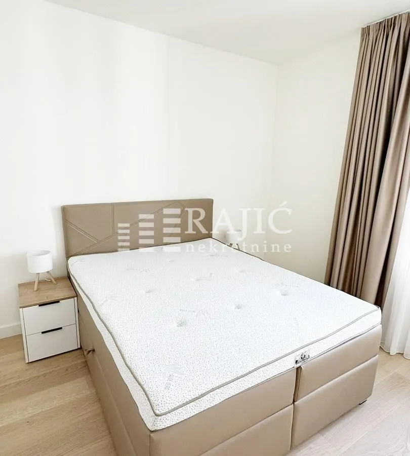 Bright bedroom with a double bed and white walls.