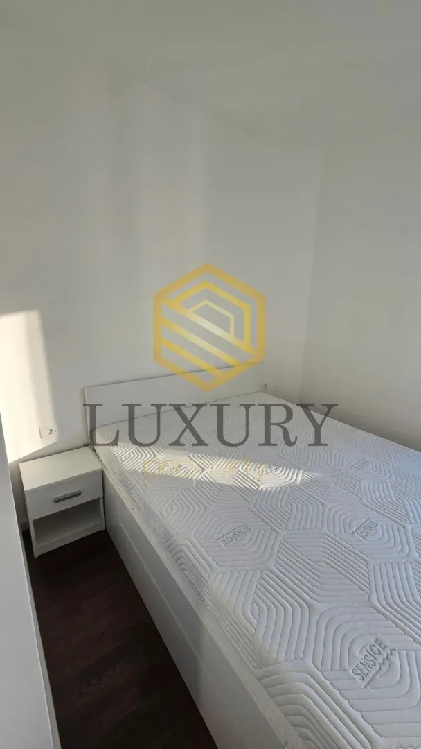 A bedroom with a double bed and a nightstand.