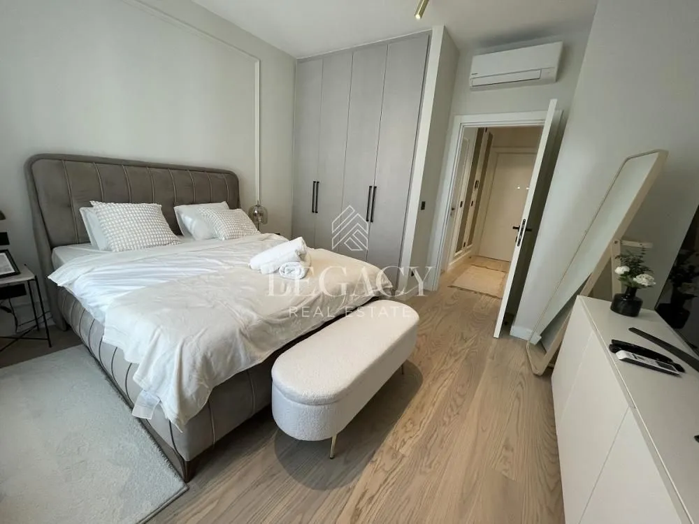 Modern bedroom with a double bed, built-in wardrobe, and wooden flooring.