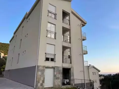 Exterior view of an apartment building with balconies and terraces.