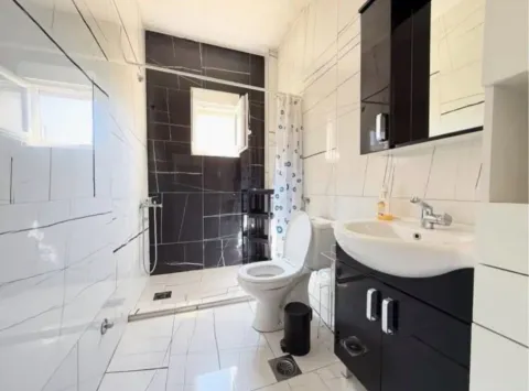Modern bathroom equipped with a walk-in shower area, toilet, and vanity sink. - image 5