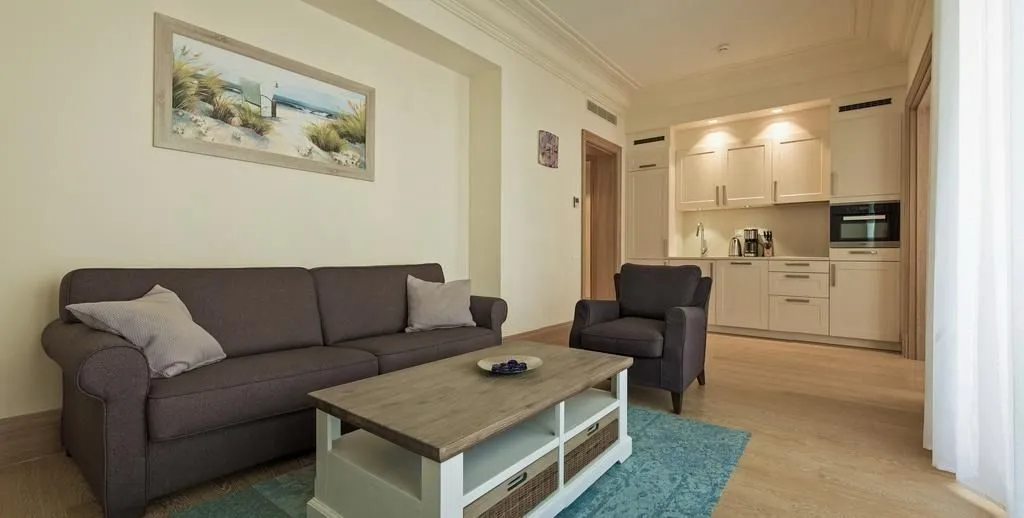 Living room connected to the kitchen in bright tones.