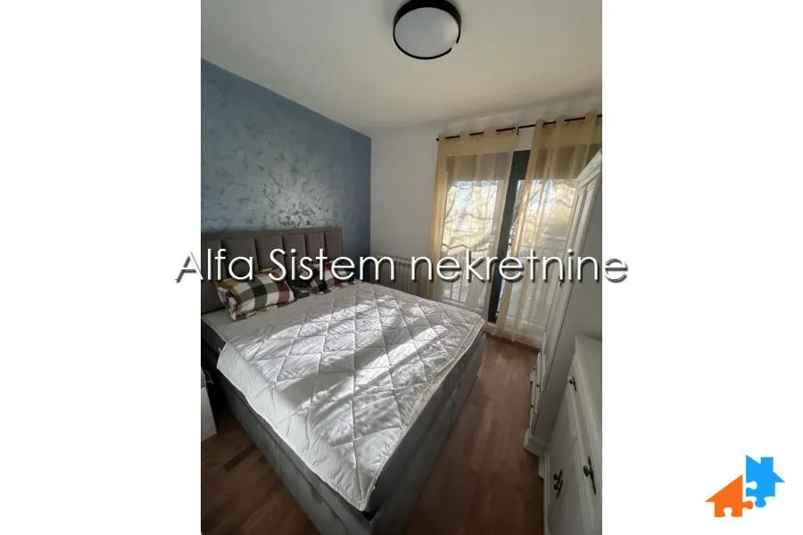 Furnished bedroom with a double bed and balcony access.