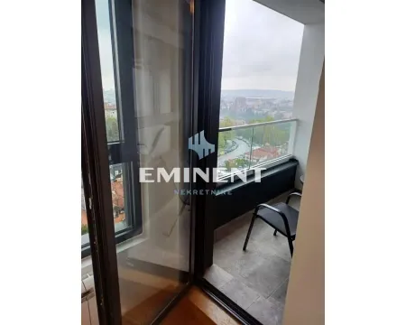 Small tiled balcony with a glass railing and a city view. - image 9