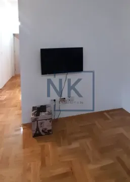 Pogled na zid sa televizorom i drvenim parketom. - image 2
