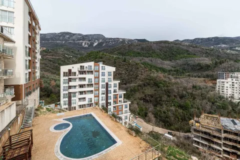 Pogled na stambeni kompleks sa bazenom i planinskim okruženjem. - image 11