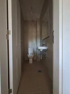 Pogled na moderno opremljeno kupatilo sa wc šoljom, umivaonikom i ogledalom. - image 7