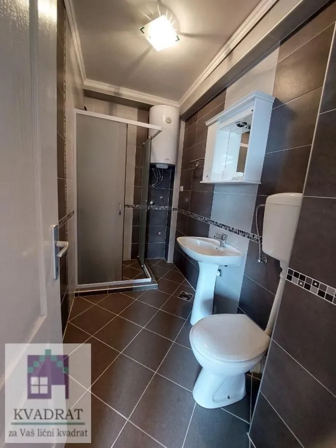 Bathroom equipped with a shower cabin, washbasin, toilet, and water heater.