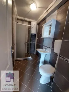 Bathroom equipped with a shower cabin, washbasin, toilet, and water heater. - image 21
