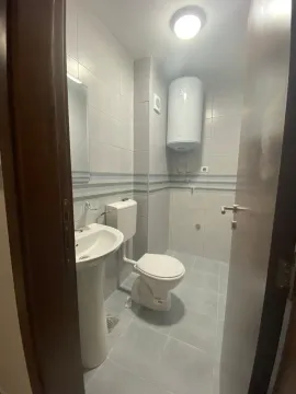 Manje kupatilo sa svijetlim pločicama, umivaonikom i wc šoljom. - image 8
