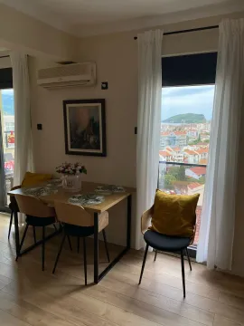 Dining area with a dining table and city view. - image 7