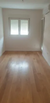 An empty room with light wooden flooring and white walls. - image 10