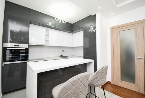 Modern kitchen with white and dark cabinets and a breakfast bar. - image 3
