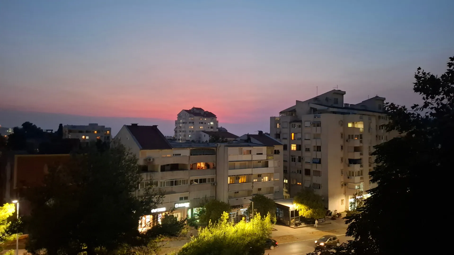 Pogled na gradske zgrade i večernje nebo sa terase.