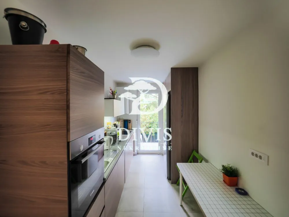 Narrow kitchen with wooden cabinetry and a built-in oven.