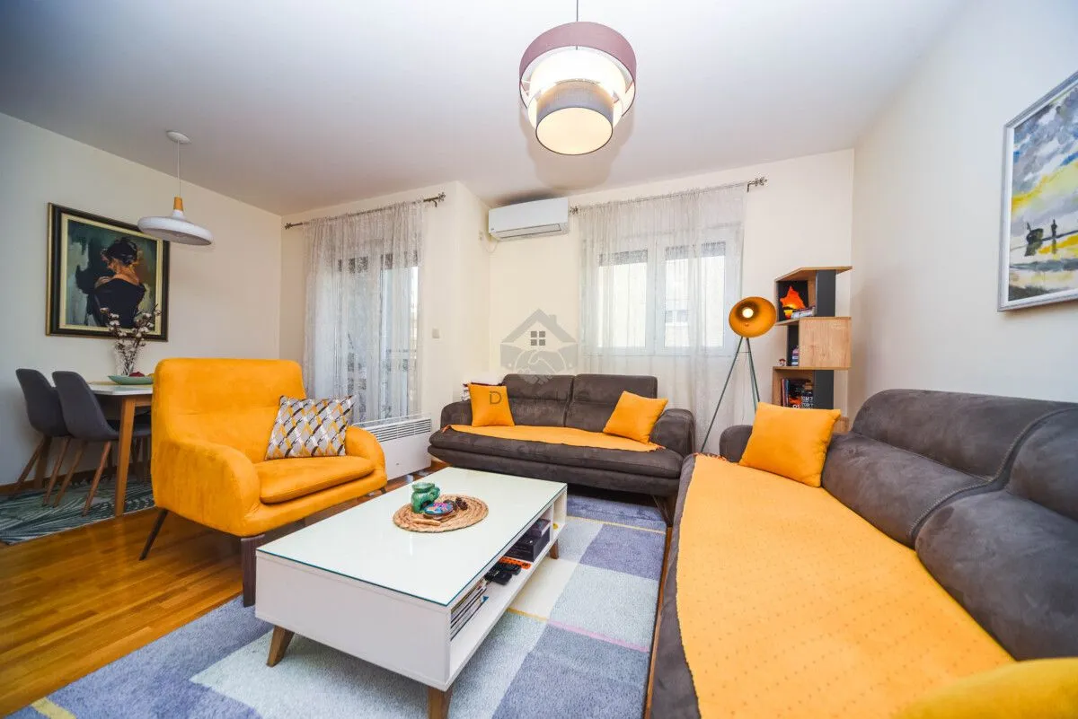 Living room with a sofa set, armchair, and a dining table in the corner.
