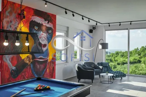 Living room with a pool table, large wall mural, and nature view. - image 7
