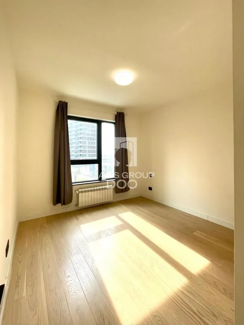 Empty room with wooden flooring and a window.